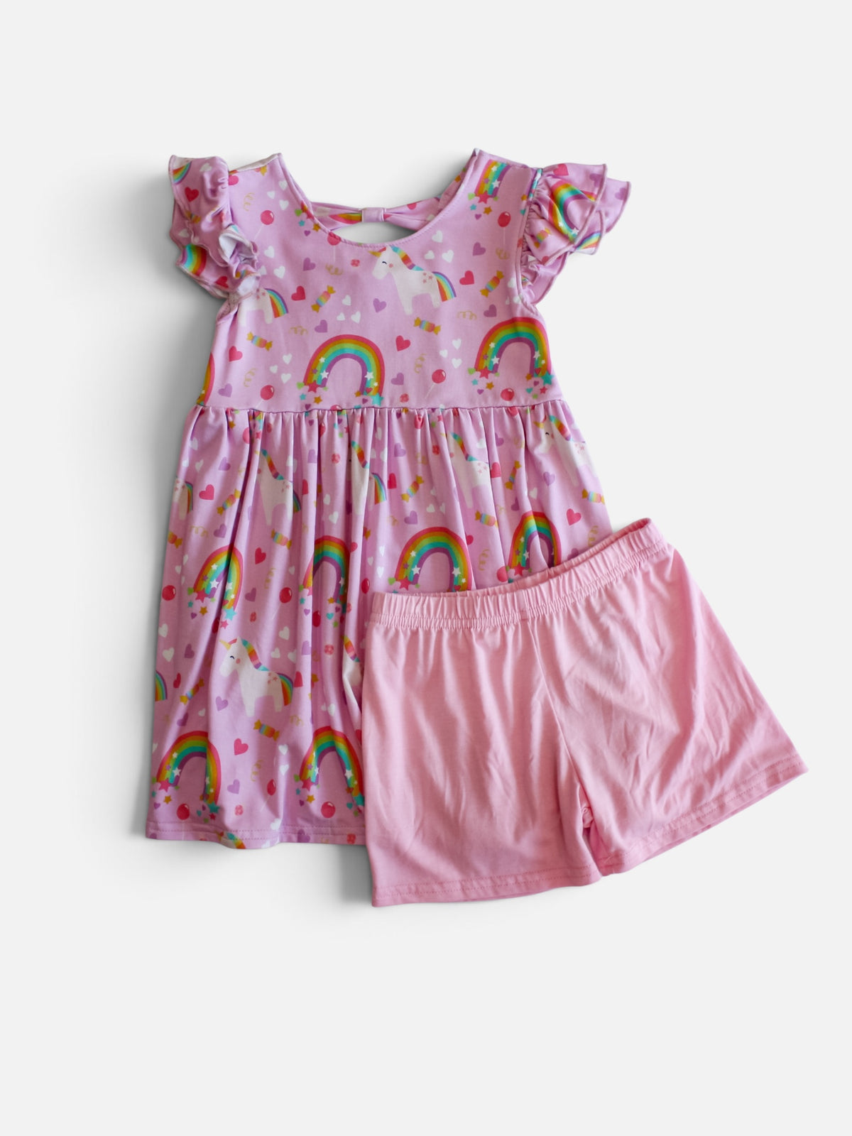 A children's two-piece bamboo viscose  outfit set featuring a pink tiered dress with ruffled sleeves and an all-over rainbow and heart print, paired with solid pink shorts, shown on a light gray background.