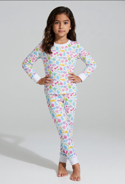Girl modeling Polly & Pearl pastel princess bamboo pajamas with colorful crowns, hearts and white cuffs