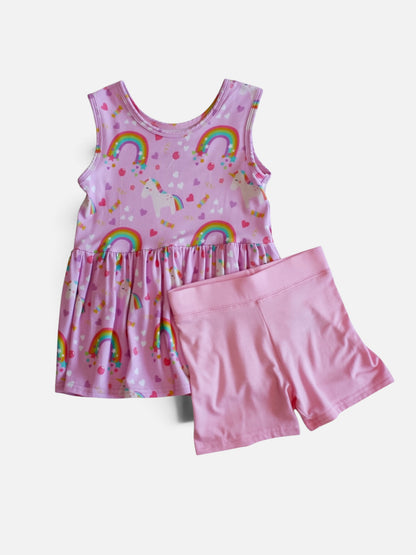  Girl's two-piece bamboo viscose clothing set featuring a sleeveless pink dress with a rainbow and unicorn print, paired with solid pink shorts, displayed on a light gray background.