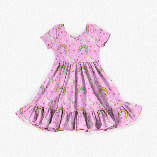 Pink girls' bamboo viscose twirl dress featuring colorful unicorns, rainbows, hearts, and stars with short sleeves, a gathered waist, and a playful ruffled hem.